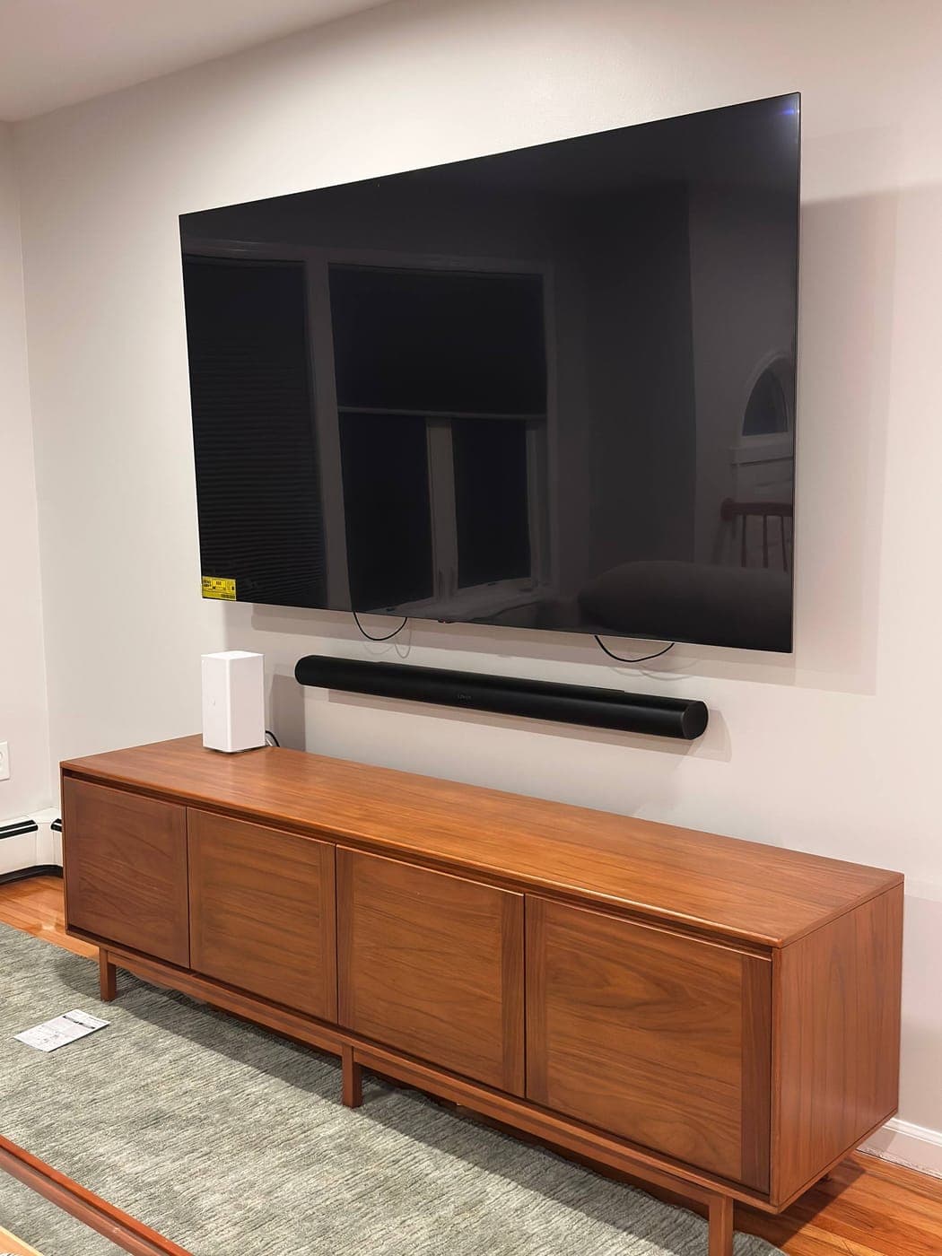 TV and soundbar mounted above a credenza in NYC