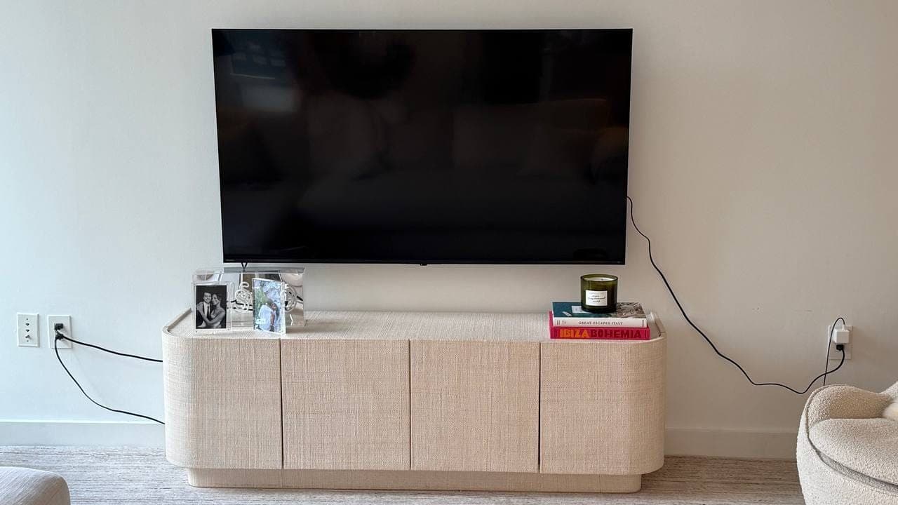 Flat-screen TV wall-mounted above a console in an NYC living room